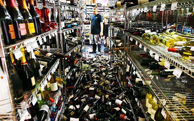 NAPA, CA - AUGUST 24: A worker looks at a pile of wine bottles that were thrown from the shelves at Van's Liquors following a reported 6.0 earthquake on August 24, 2014 in Napa, California. A 6.0 earthquake rocked the San Francisco Bay Area shortly after 3:00 am on Sunday morning causing damage to buildings and sending at least 70 people to a hospital with non-life threatening injuries. Justin Sullivan/Getty Images/AFP